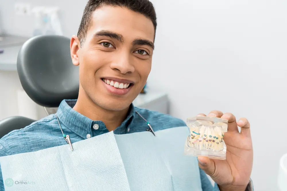 a man holding a dental model after being explained about  how long do braces take in Bakersfield and Tehachapi, CA