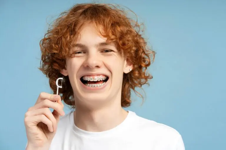 close up image smiling teenager curly red hair metal braces - How to Floss with Braces in Bakersfield and Tehachapi, CA.