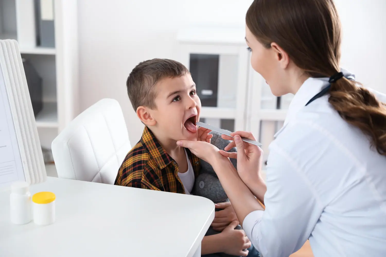 A healthcare professional checks a child's throat for tongue thrust treatment at Gianquinto Orthodontic Arts in Bakersfield, Tehachapi or Mammoth Lakes, CA.