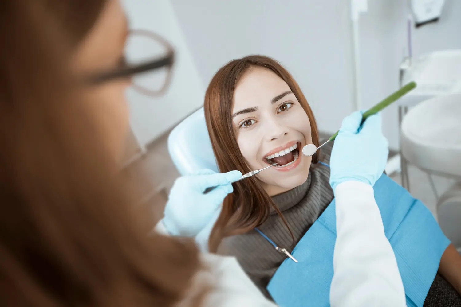 A dentist examines a young woman's teeth in a clinic chair for orthodontic appliance treatment process at Gianquinto Orthodontic Arts in Bakersfield, CA