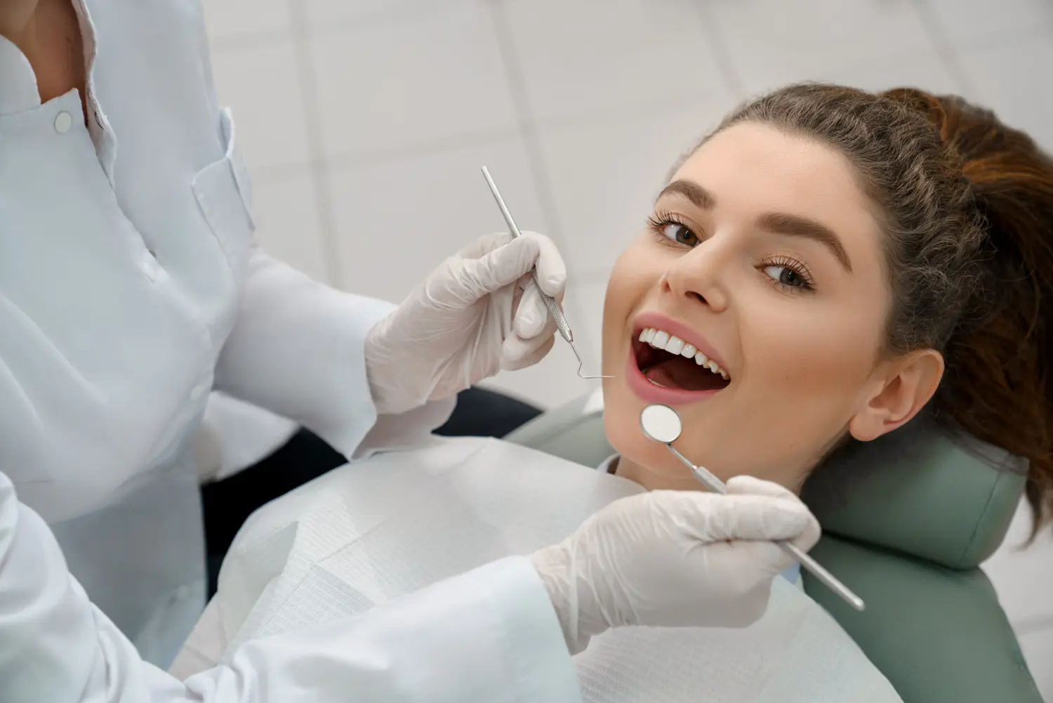 A dentist examines a young woman's teeth near orthodontic appliances at Gianquinto Orthodontic Arts in Tehachapi, CA