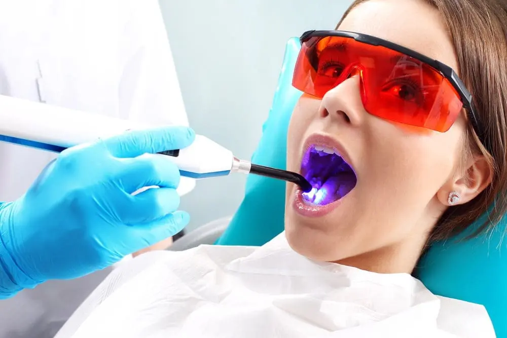 A dentist at Gianquinto Orthodontic Arts in Bakersfield, Tehachapi and Mammoth Lakes, CA, showing Investment and Oral Hygiene and discussing Invisalign vs braces for dental care.