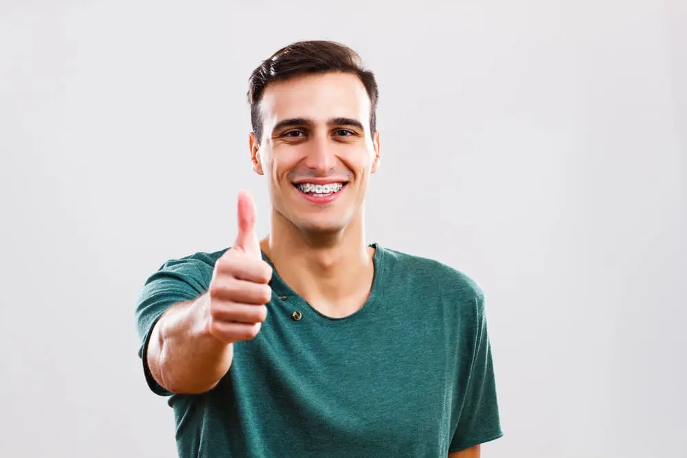 Smiling young man with metal braces highlighting adult orthodontics from Gianquinto Orthodontic Arts in Bakersfield, Tehachapi and Mammoth Lakes, CA.