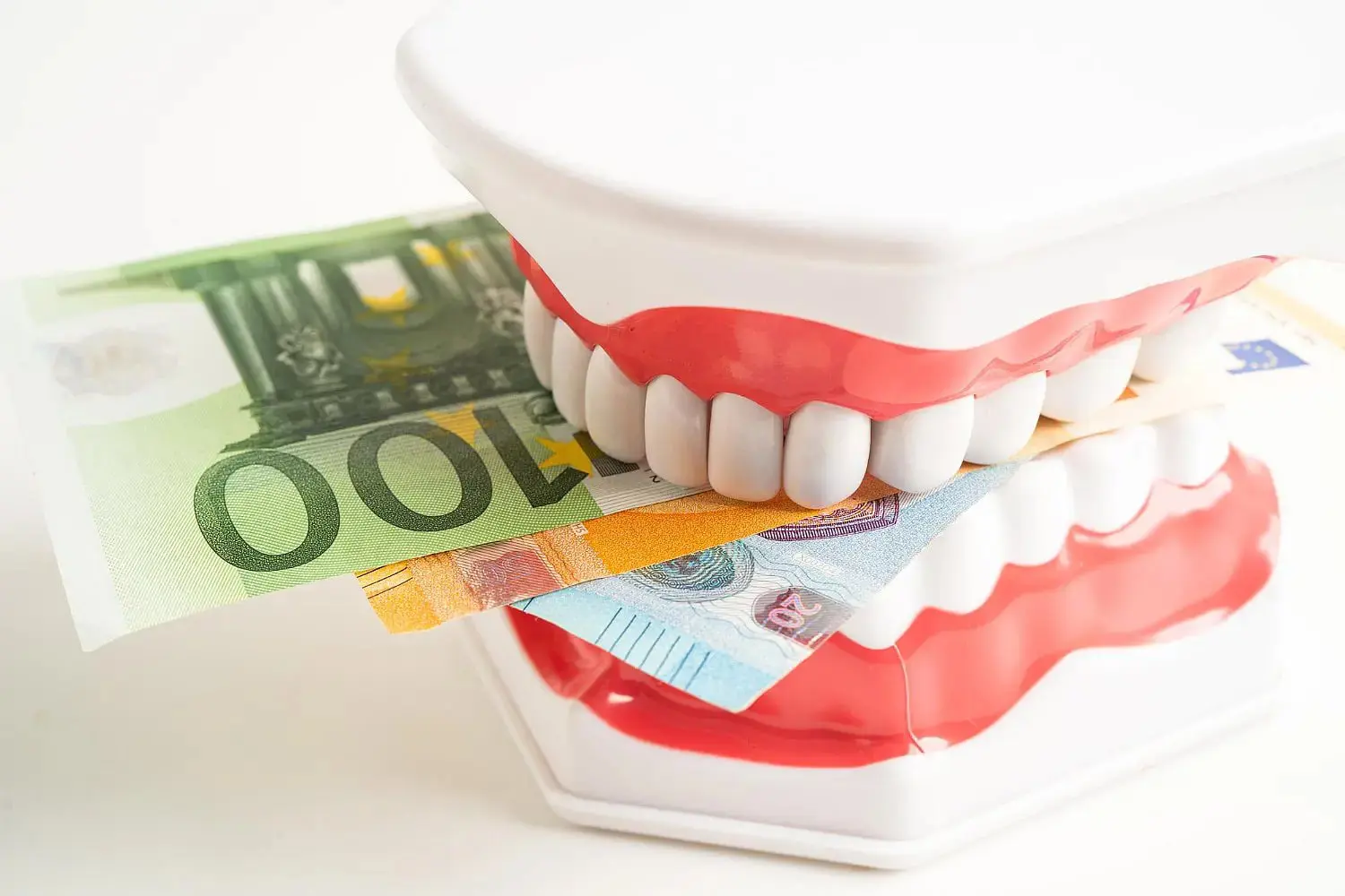 Fake teeth and money, representing Orthodontic Insurance Costs at Gianquinto Orthodontic Arts in Bakersfield, Tehachapi or Mammoth Lakes, CA