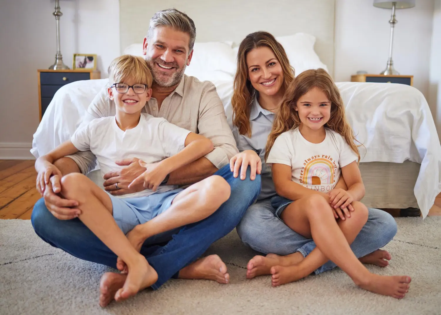 A smiling family with two kids sits together considering the type of braces from Gianquinto Orthodontic Arts in Bakersfield, Tehachapi or Mammoth Lakes, CA