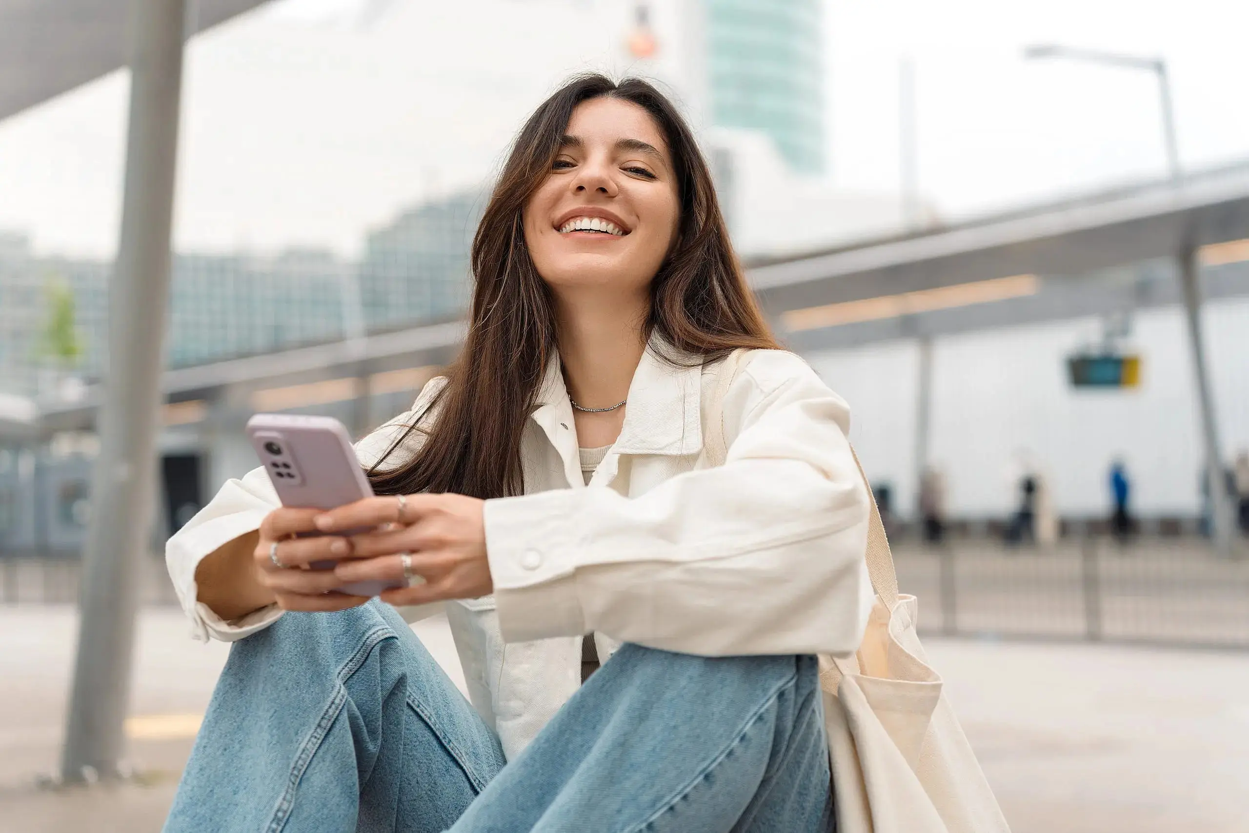 A woman in jeans and a jacket smiles confidently after MARPE treatment by Gianquinto Orthodontic Arts in Bakersfield, Tehachapi or Mammoth Lakes, CA