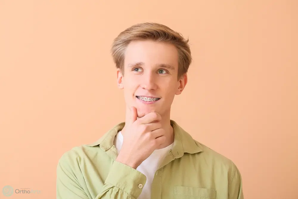 handsome man metal braces color background - How Long Does It Take To Get Used To Braces in Bakersfield, CA 