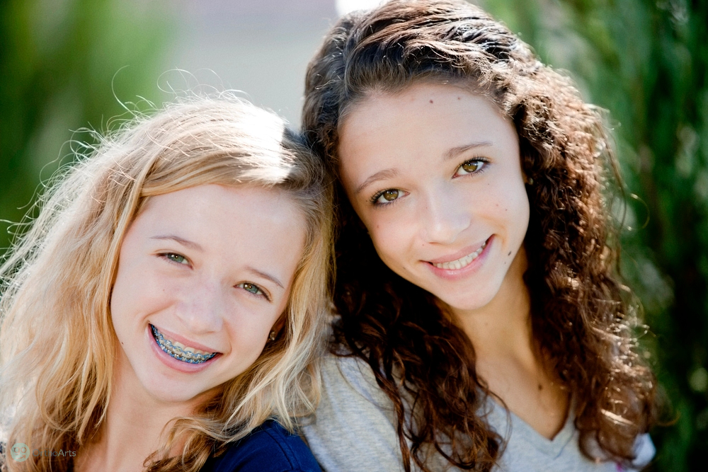 Two smiling young girls, one with braces, showcasing orthodontic solutions for how to fix overbite in Bakersfield and Tehachapi, CA.