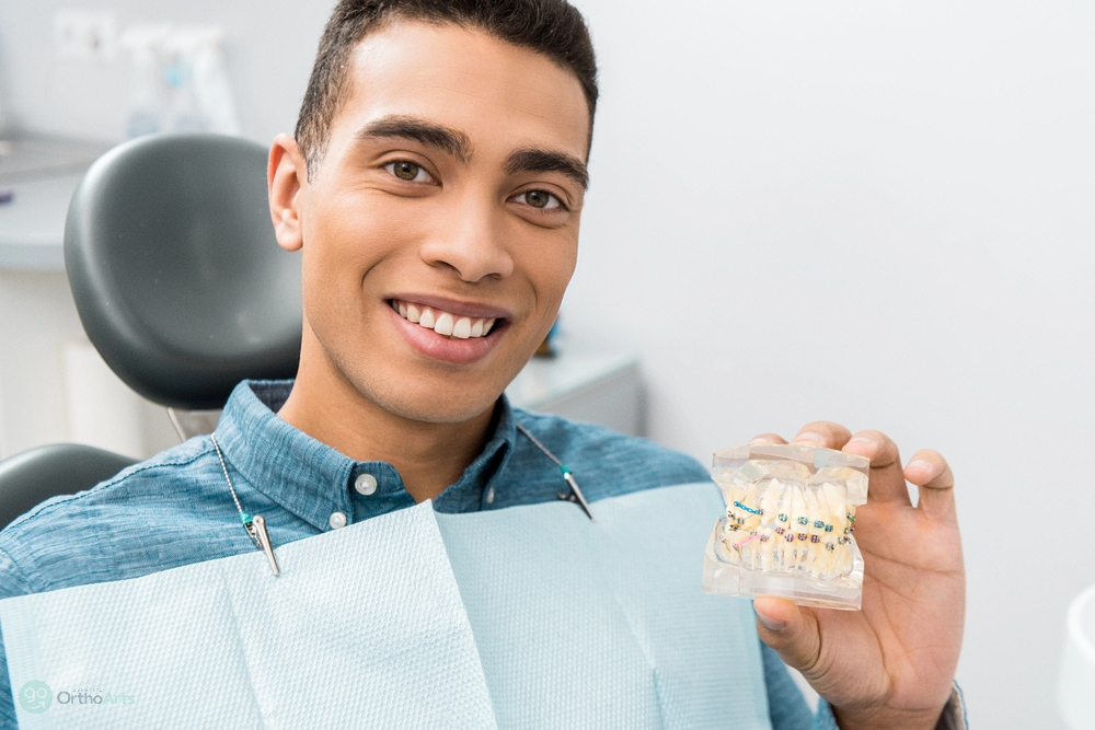 a man holding a dental model after being explained about  how long do braces take in Bakersfield and Tehachapi, CA