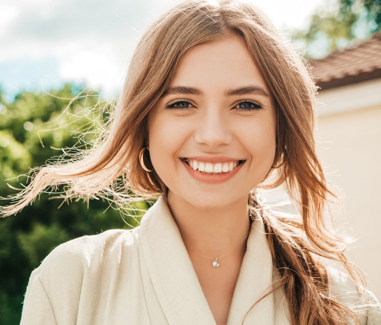 Smiling young woman outdoors, showing confidence after orthodontic care with adult braces from Gianquinto Orthodontic Arts in Bakersfield, Tehachapi or Mammoth Lakes, CA.