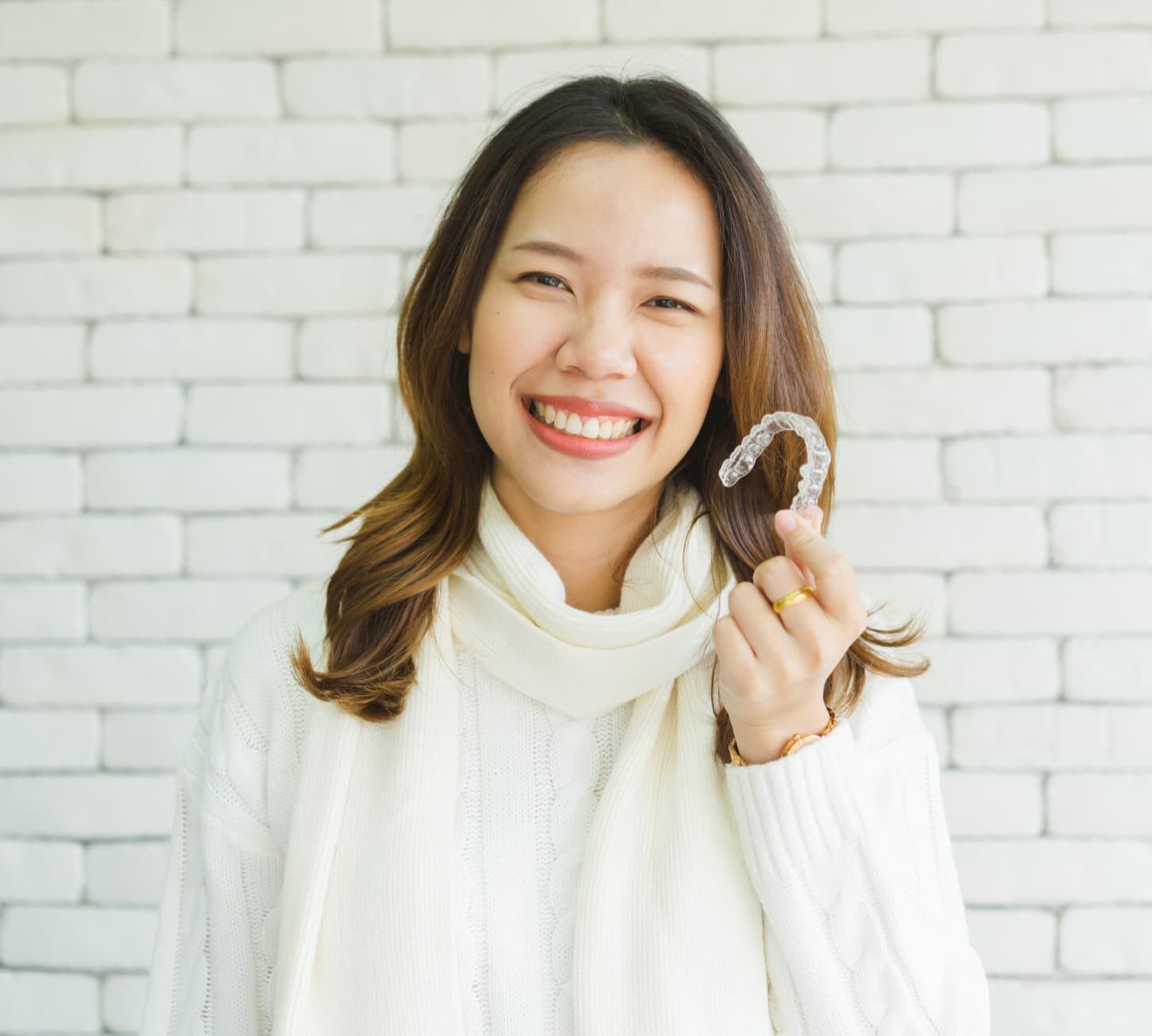 Woman holds a Invisalign Affordable at Gianquinto Orthodontic Arts in Bakersfield, Tehachapi or Mammoth Lakes, CA